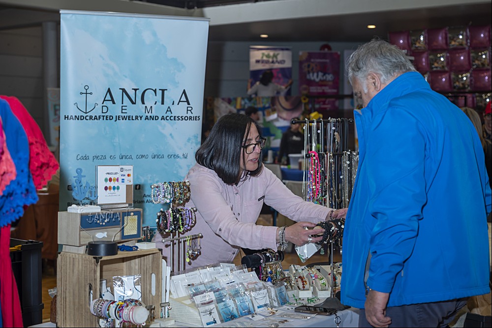 Emprendedora mostrando joyería artesanal en su stand